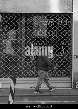 Unidentifizierte wenige Menschen in leeren Straßen im Jahr 2020 sperren sich und Ausbruch in Cremona, Italien unter Quarantäne Stockfoto