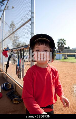 Kleiner Junge lächelt in der Nähe der TBall Dugout Stockfoto