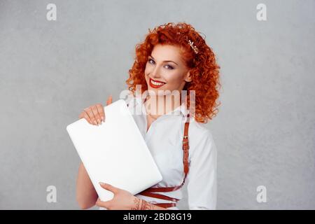 Ich bin mit meinem Laptop zufrieden. Closeup Portrait Head Shot professionell schöne selbstbewusste junge Geschäftsfrau hält Computer isoliert grauen Studio Wand Backg Stockfoto