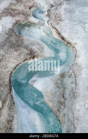 Schlängelnder Gletscher-Schmelzwasserstrom auf der Oberfläche des Snowbird-Gletschers, Talkeetna Mountains, Alaska. Stockfoto