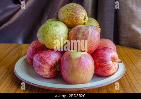 Äpfel und Birnen auf einem Tisch gestapelt. Stockfoto