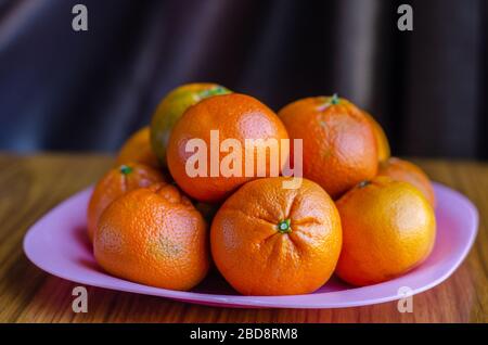 Frische Mandarinorange Früchte auf einem Teller in einem Standbild. Stockfoto
