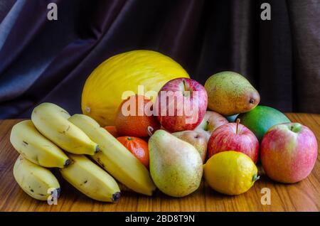 Ein Standbild mit verschiedenen Obstsorten, darunter Äpfel, Mandarinorangen, Melone, Banane, Birnen, Mango, Zitrone Stockfoto