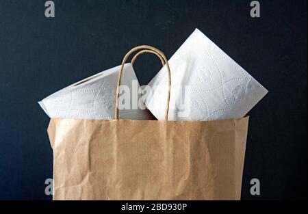 Recycling-Toilettenrollen Papier lose in braunen Papierträgertasche vor schwarzem Hintergrund. Konzept ohne Verschwendung Stockfoto