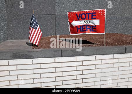 Ein Schild mit dem Hinweis „Stimme hier ab“, der auf eine kleine US-Flagge vor einem Wahlort in Cleveland, Ohio, USA zeigt. Stockfoto