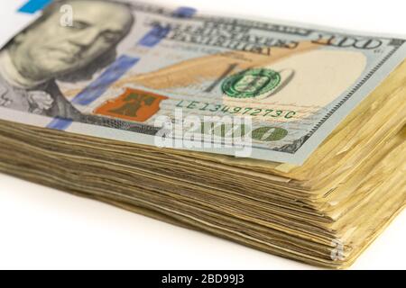 Stapel amerikanischer Dollar mit einer Rechnung von 100 Dollar oben isoliert auf einem weißen Hintergrund. Stockfoto