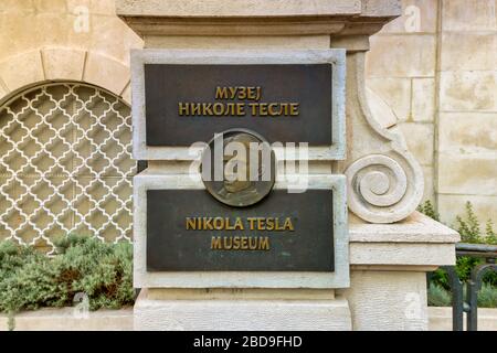Nikola Teslas Gesichtsporträt auf einer Metallplatte am Eingang des Nikola Tesla Museums. Serbischer Text auf dem Teller bedeutet Nikola Tesla Museum auf Englisch. Stockfoto