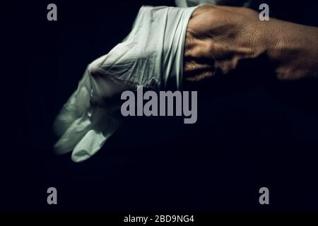 Nahaufnahme eines Pflegearbeiters, der chirurgische Handschuhe trägt Stockfoto