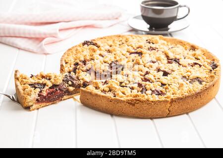 Süße Pflaumenkuchen. Kreis auf weißem Tisch schneiden. Stockfoto
