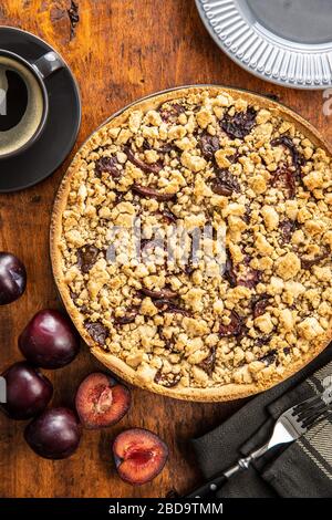 Süße Pflaumenkuchen und Pflaumen auf Holztisch. Draufsicht. Stockfoto