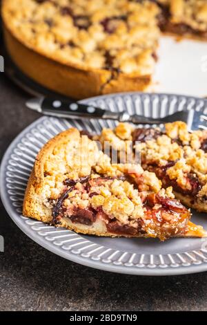 Süße Pflaumenkuchen. Schneiden Sie die Kreisdiagramme auf der Platte. Stockfoto