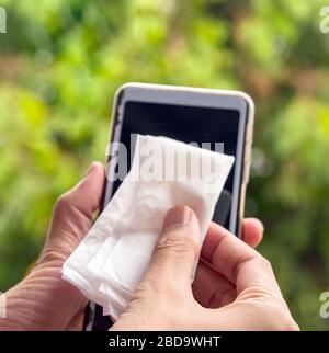 Reinigen des Bildschirms des Mobiltelefons mit Softpapier . Coronavirus, Covit-19 Prävention und Desinfektion. Stockfoto