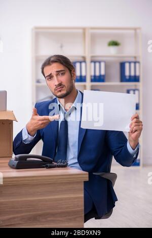 Junger Mann, der von seinem Arbeitsplatz aus gefeuert wird Stockfoto