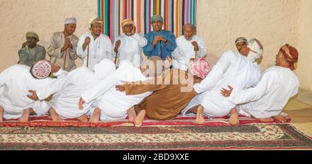 Omanische Männer eine Ritual durchführen, in ihren Majlis (traditioneller Treffpunkt) in Maskat, in das Sultanat Oman. Stockfoto