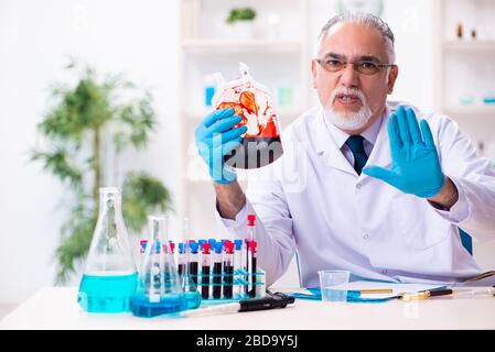 Der alte, im Labor arbeitende Chemiker Stockfoto