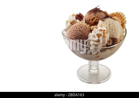 Schokolade und Vanilleeis mit Schlagsahne, die mit Nüssen und Schokoladenflocken bestockt ist, werden in einer Glasschale auf weiß mit Kopierraum serviert Stockfoto