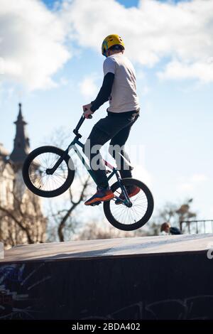 Lemberg, Ukraine - 12. März 2020: Junger Mann, der Tricks auf einem BMX-Fahrrad macht. BMX im Skatepark der Stadt. Teenager fahren mit dem Fahrrad in einem urbanen Bike- und Skatepark Stockfoto