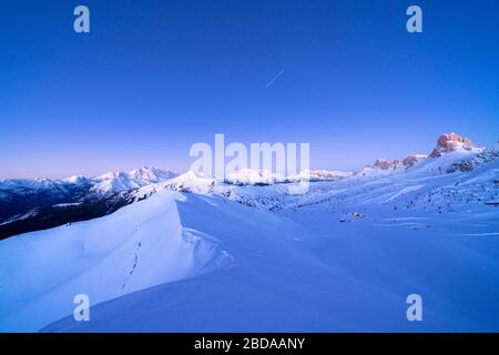 Abenddämmerung über Giau-Pass mit Schnee bedeckt mit Marmolada im Hintergrund, in den Bergen, in der Provinz Belluno, in Venetien, Italien Stockfoto