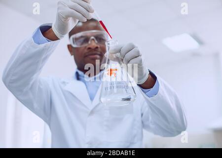 Seriöser intelligenter männlicher Wissenschaftler mit Schutzbrille Stockfoto