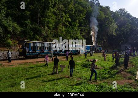 Passagiere steigen aus dem Zug für eine kurze Pause an einer der Halts auf Nilgiri Mountain Railway, Tamil Nadu, Indien Stockfoto