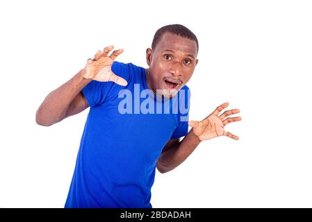 Ein junger Mann in einem blauen T-Shirt, das auf einem weißen Hintergrund steht und mit verängstigtem Aussehen wegblickt. Stockfoto