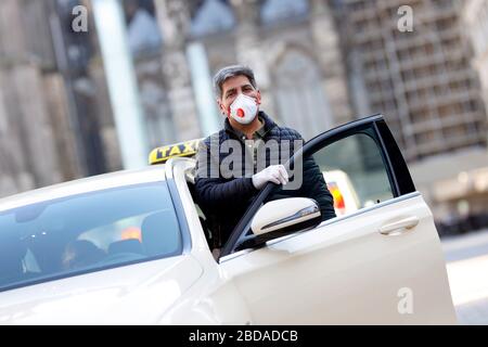 Köln, Deutschland. April 2020. Ein Taxifahrer schützt sich und seine Kunden mit Handschuhen und einem Atemschutzgerät. Koln, 7. April 2020 - weltweite Nutzung Credit: Dpa/Alamy Live News Stockfoto