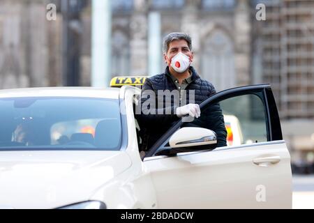 Köln, Deutschland. April 2020. Ein Taxifahrer schützt sich und seine Kunden mit Handschuhen und einem Atemschutzgerät. Koln, 7. April 2020 - weltweite Nutzung Credit: Dpa/Alamy Live News Stockfoto