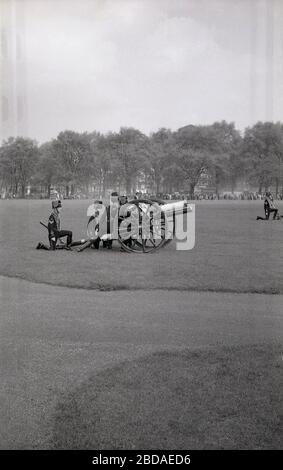 1960er Jahre, historisch, Rauch aus dem Abschuss von alten Gewehren füllt die Luft auf einem Royal Gun Salute im Green Park in der Nähe von Buckingham Palace, Westminster, London, England. Gun Salutes markieren besondere königliche Anlässe einschließlich der Königin Geburtstag und sind eine traditionelle Darstellung der britischen Prunk. Stockfoto