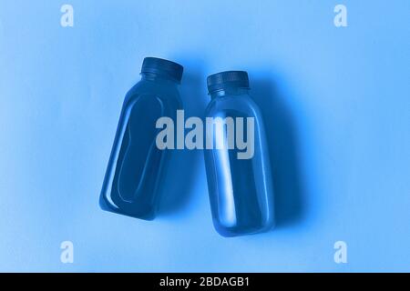 Minimaler Stil. Klassische blaue Farbe des Jahres 2020. Das gesunde Getränk in Eco-Flaschen tönte in klassischer blauer Farbe des Jahres 2020 gegenüber dem trendigen Klassiker Stockfoto