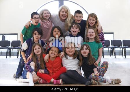 Portrait Der Gruppe Der Kinder Mit Lehrer, Die Gemeinsam Am Schauspiel-Workshop Teilnehmen Stockfoto