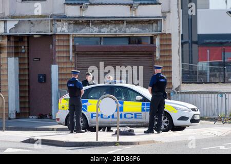 Eine Polizeipatrouille mit Beamten der Community Support verhandelt mit einem Mann in Weston-super-Stute während der Sperrung von Coronavirus Stockfoto