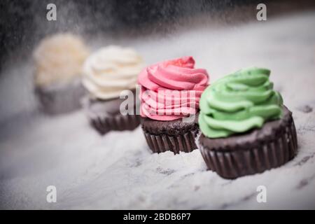 Mini-Kaffee Cupcakes mit bunten Topping Cream Stockfoto