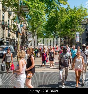 BARCELONA, SPANIEN - 10. JULI: Eine Menschenmenge in La Rambla am 10. Juli 2015 in Barcelona, Spanien. Tausende Menschen gehen täglich zu Fuß durch diese beliebte Fußgängerzone Stockfoto