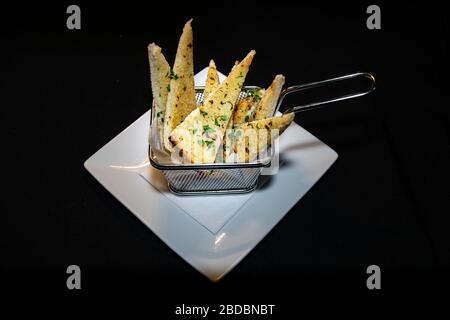 Eine Portion frisch gebackenes Knoblauchbrot, serviert in einem Mini-Brattablett Stockfoto