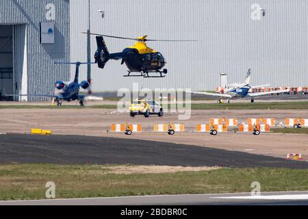 Ein Polizeihubschrauber nimmt an der provisorischen Leichenhalle am Flughafen Birmingham Teil, die angeblich in den nächsten Tagen einsatzbereit sein soll, da Großbritannien weiterhin in Sperrungen ist, um die Ausbreitung des Coronavirus einzudämmen. Stockfoto