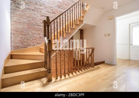 Holztreppe in der Wohnung mit einer Ziegelwand Stockfoto