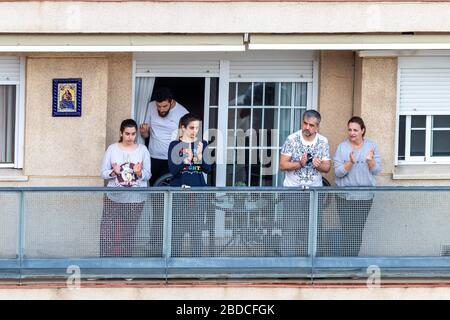 Huelva, Spanien - 7. April 2020: Bürger, die zu Hause bleiben und jeden Tag um 20 Uhr auf einem Balkon klatschen, während der Epidemiezeit des tödlichen Coronavirus. Stockfoto