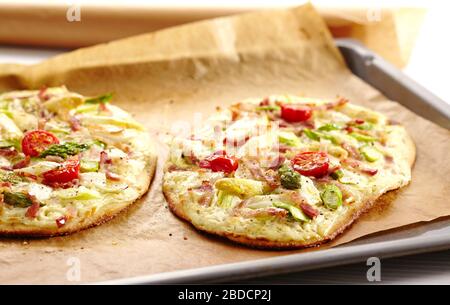 Pizza mit Spargel, Speck und Tomate Stockfoto