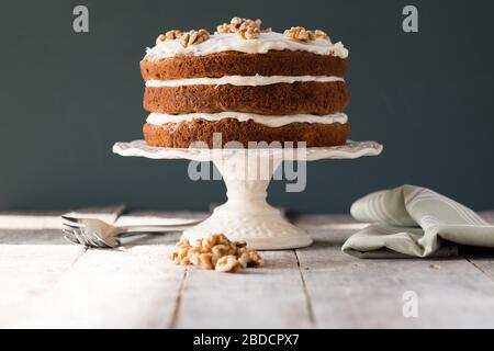 Dreistufiger Karottenkuchen mit Zuckerguss auf Kuchenständer Stockfoto