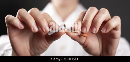 Hört auf zu rauchen, eine defekte Zigarette in den Händen eines Arztes. Stockfoto