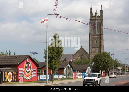 15.07.2019, Belfast, Nordirland, Großbritannien - politische Wandbilder, Newtownards Road, protestantisches East Belfast, auf der rechten Seite St Patrick's Church o Stockfoto