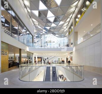 Mehrstufige Einkaufsstraßen unter Oberlicht. Westfield White City, London, Großbritannien. Architekt: UNStudio, 2018. Stockfoto