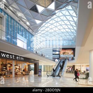 Mehrstufige Einkaufsstraßen unter Oberlicht. Westfield White City, London, Großbritannien. Architekt: UNStudio, 2018. Stockfoto