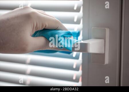 Reinigung und Desinfektion von Türgriffen und Fenstergriffen mit Reinigungstuch gegen Viren und Keime. Stockfoto