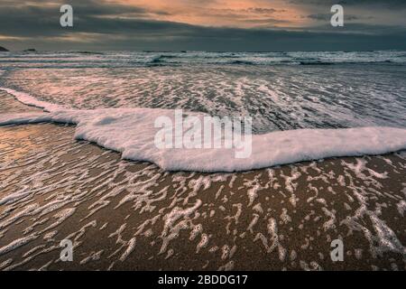 Abendlicht über eine Flut am Fistral Beach in Newquay in Cornwall. Stockfoto