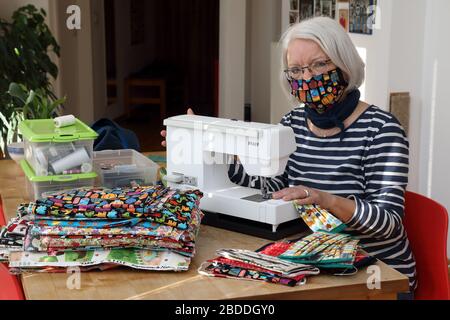 25.03.2020, Berlin, Deutschland - Rentner näht Stoff-Mundschutz in ihrem Wohnzimmer wegen Lieferengpässen in Zeiten der Corona-Krise. 00S20032 Stockfoto