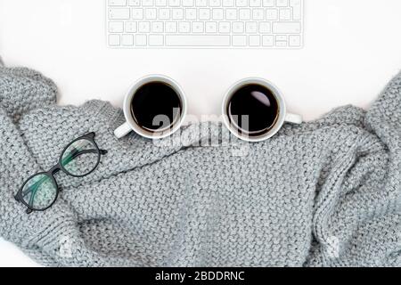 Flaches Lay mit gemütlichem Schreibplatz oder Film mit warmem Pullover und 2 Tasse Kaffee, Laptop von zu Hause aus. Schreiben. Warmes Konzept für Coupl Stockfoto