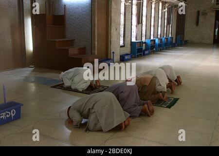 Bangladeschische Muslime nehmen während der Coronavirus-Krise in Dhaka an gebeten in einer Moschee Teil.Bangladesch suspendierte alle Gebete, einschließlich Freitagskongregationen, in Moscheen im Rahmen der Bemühungen, die Verbreitung von COVID-19 einzudämmen. Es wurde klargestellt, dass fünf Männer, der Imam (Betleiter), Muezzin (Person, die andere zu gebeten aufruft) und drei weitere Moscheebeamte täglich in Moscheen beten dürfen. Stockfoto