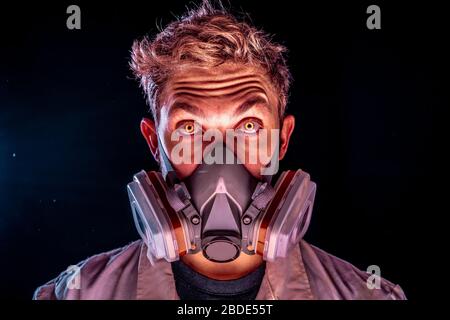 Böse und gruselig Wissenschaft Experiment Konzept, ein unheimlich Wissenschaftler in Gasmaske Atemschutzmaske mit gelb glühenden Dämon Augen auf eine dunkle staubige Umgebung tragen Stockfoto