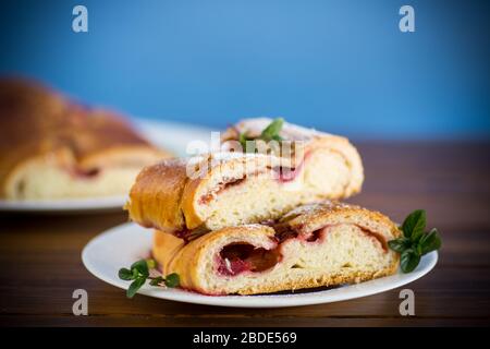 Süß gebackener Hefekuchen mit Beeren auf einem Holztisch Stockfoto